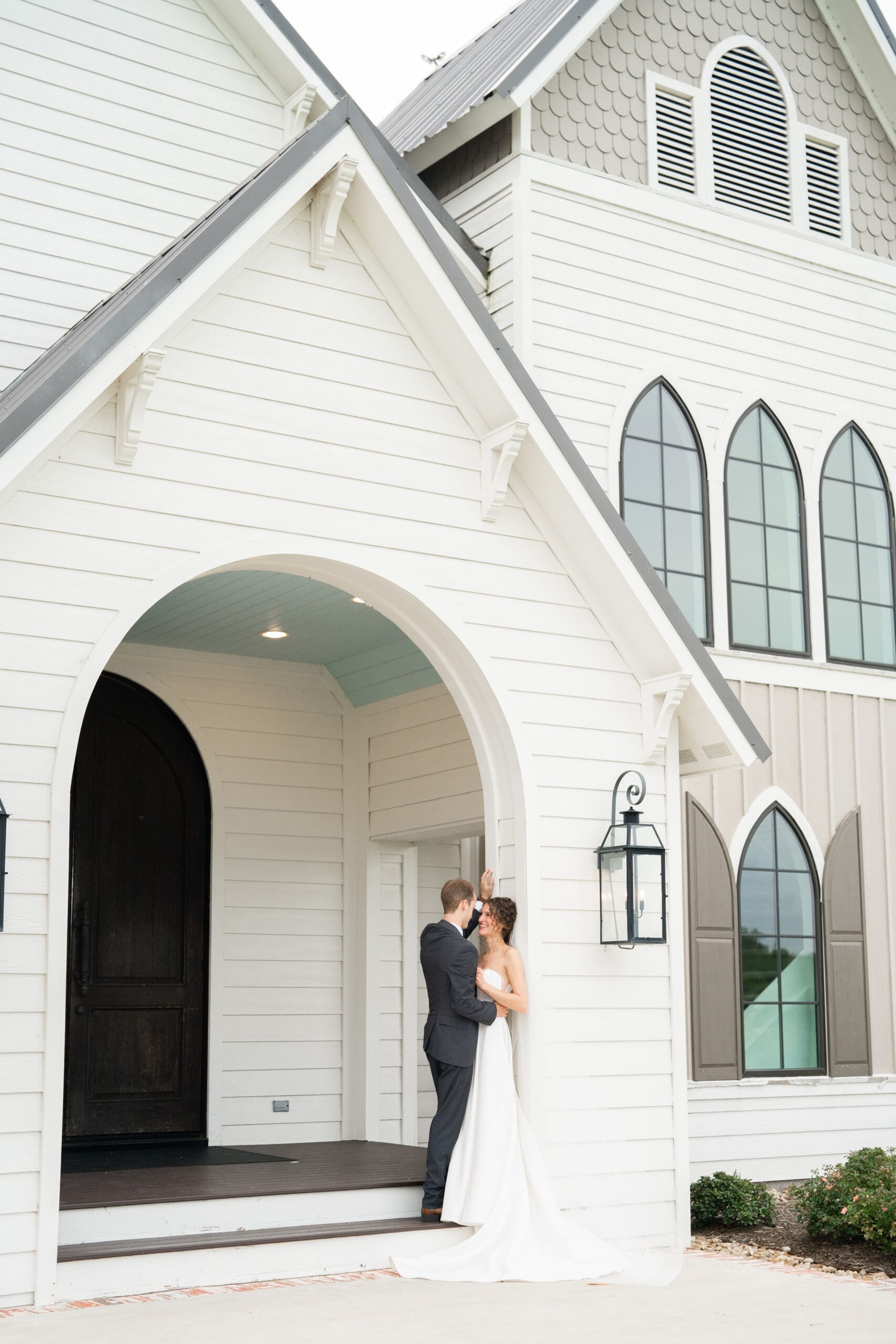 bride and groom pose outside of deep in the heart farms wedding venue in college station