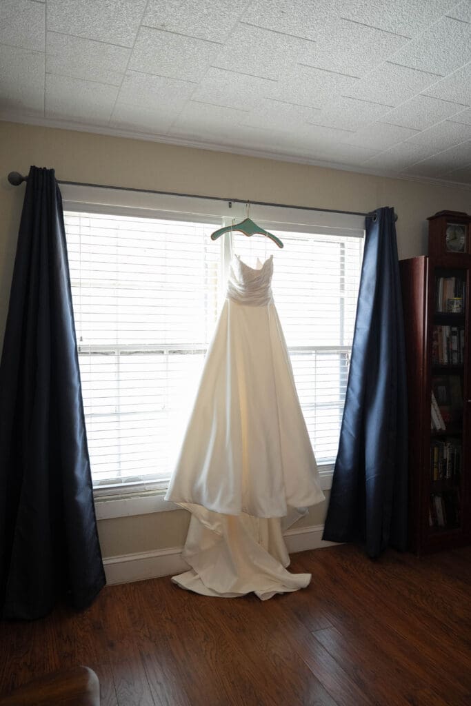 Bride's dress hanging in window of childhood home