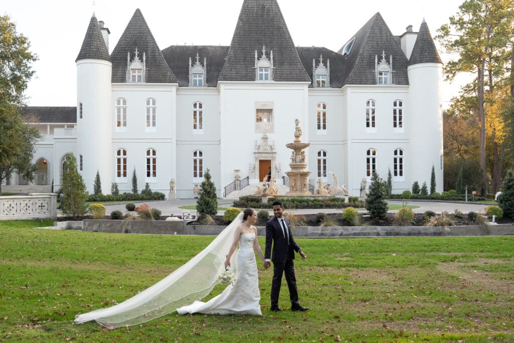 bride and groom walk in front of chateau nouvelle at their wedding